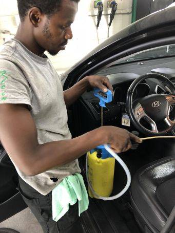 Hyundai auto interieur reinigen met gele blauwe drukspuit in garage bij Klein Autopoets Groningen autoverzorging