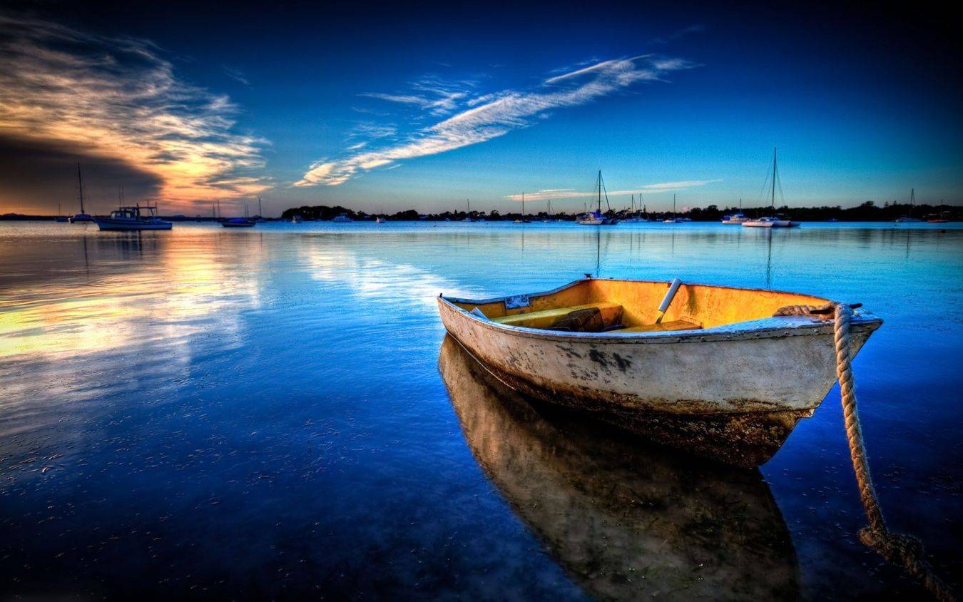 Boot op kalm water bij zonsondergang met reflecties en andere zeilboten achtergrond scène rust natuur boten vaartuigen
