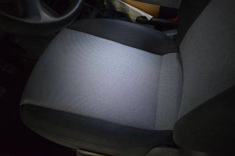 Close-up van autostoel met lichtgrijs en donkergrijs textuur in interieur van auto klein autopoets groningen