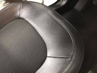 Close-up autostoel met hexagon patroon en glad materiaal detail naaimachinewerk autocosmetica groningen