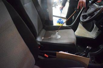 Interieurauto met schuim op bestuurdersstoel tijdens reiniging autostoelen klein autopoets groningen