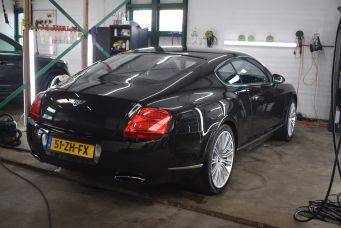 Luxe zwarte sportauto met kenteken 51-ZH-FX in garage met werkbank en gereedschap - onderhoud en autoverzorging