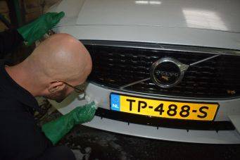 Voertuig schoonmaken met schuim en spons op een witte Volvo met kenteken TP-488-S NL in garage Klein Autopoets Groningen