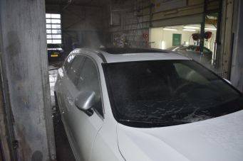 Witte auto in werkplaats groningen met donkere ramen en gereedschap op achtergrond klein autopoets