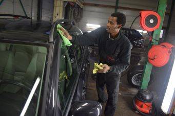 Autoverzorging bij Klein Autopoets Groningen toont schoonmaken zwart auto dak en raam in werkplaats