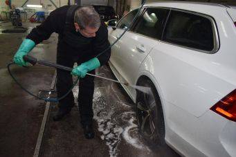 Professioneel reinigen van witte auto met hogedrukreiniger in garage kleinautopoets groningen