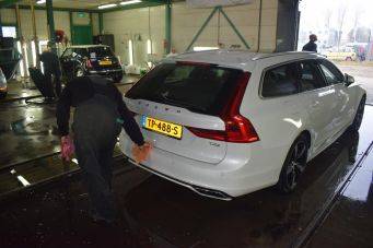 Binnenruimte autowas- en onderhoudsruimte met witte Volvo stationwagen kenteken TP-488-S schoonmaakactiviteit in Groningen