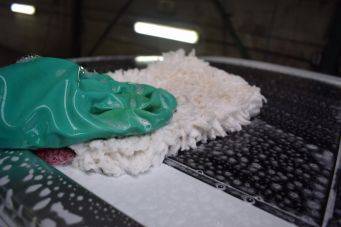 Close-up van autowassen met schuurspons en zeepsop, autoverzorging artikel annemarie jager groningen