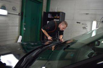 Autotechniek in garage autopoets groningen persoon inspecteert zwarte auto motorkap