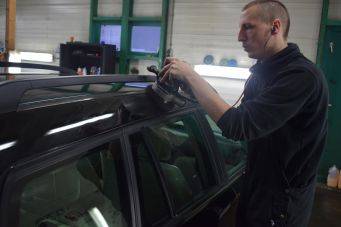 Autopolijsten in werkplaats met elektrische polijstmachine op autolak voor glans en onderhoud