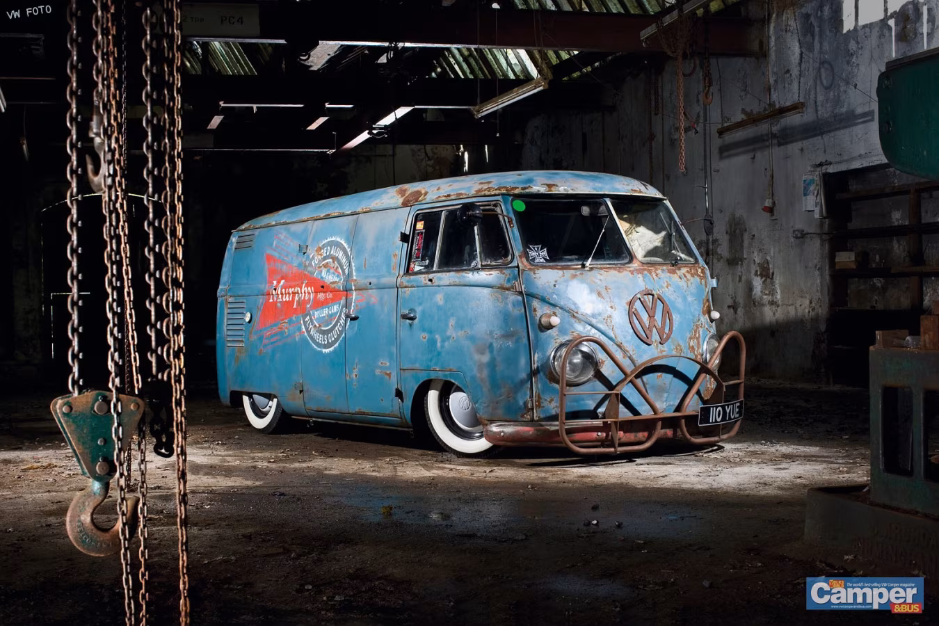 Oude blauwe volkswagen camperbus met roest in donkere industriële garage bussen reinigen klein autopoets
