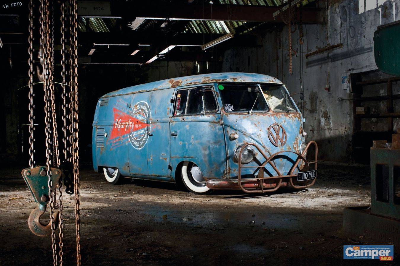 Oude blauwe volkswagen camperbus met roest in donkere industriële garage bussen reinigen klein autopoets