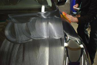 Auto-detailing proces geshowd met glanzend gepolijste en wit gecoate motorkap in garage volgens Klein Autopoets Groningen