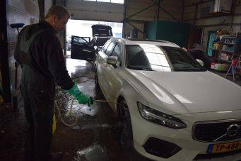 Binnenruimte van Klein Autopoets Groningen met witte auto en autopoetsproces in garage
