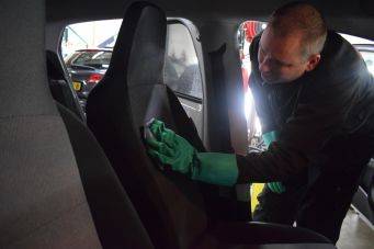 Schoonmaak autointerieur bekleding autostoel groene handschoenen doek onderhoud garage groningen