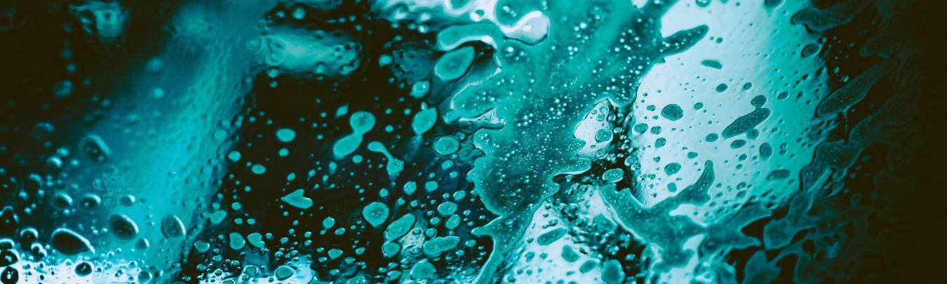 Close-up glasoppervlak met waterdruppels en condensatie in blauwgroene tinten sfeer van regen en vochtigheid klein glascoating